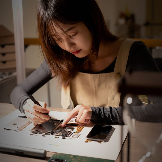 Technician testing a smartphone as part of certified pre-owned grading