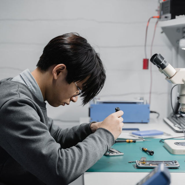 Technician diagnosing a device for certified pre-owned grading