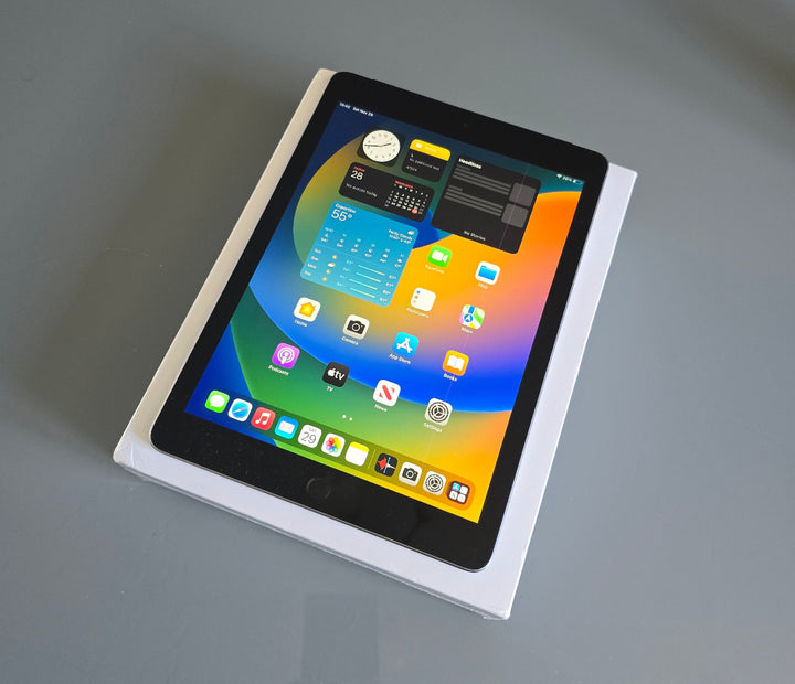 Tablet with colorful display on a white box against a gray background